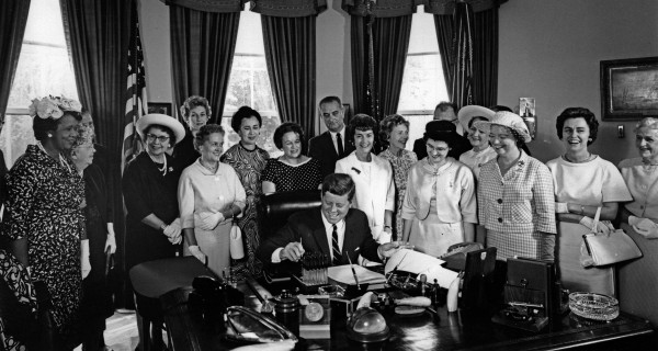 Surrounded by top women leaders, President John F. Kennedy signed the Equal Pay Act into law on June 10, 1963. The act made it illegal for employers to pay women and men different wages for the same work. (Credit: Abbie Rowe, White House Photographs. Courtesy of John F. Kennedy Presidential Library and Museum, Boston)