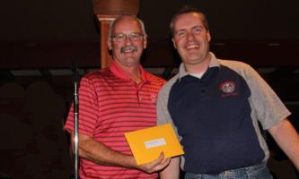IAM District 250 Business Representative Al Cyr, on left, awards the grand prize to District 250 member Sam Lange at the district’s inaugural Guide Dogs of America charity golf tournament.
