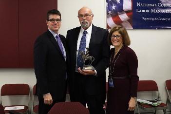 NFFE-IAM National President William R. Dougan, center, accepts the Theodore Roosevelt Award from Office of Personnel Management Director Beth Cobert, right, and Deputy Director Andrew Maycock, left. 